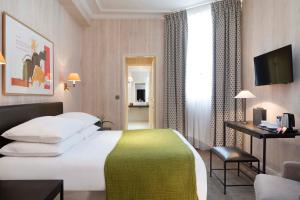 Habitación de hotel con cama y escritorio en Hôtel du Danube Saint Germain, en París