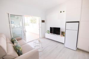 a living room with a couch and a sliding glass door at Deluxe Apartment. 50 meters Beach in San Agustin