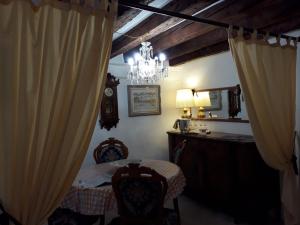a bedroom with a table and a chandelier and curtains at Cà Del Giazzo in Venice