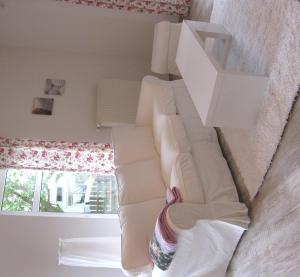ein weißes Sofa in einem Zimmer mit Fenster in der Unterkunft Holiday Rügen Putbus in Putbus
