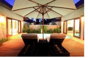a table and chairs with an umbrella in a house at Kebun Villas & Resort in Senggigi