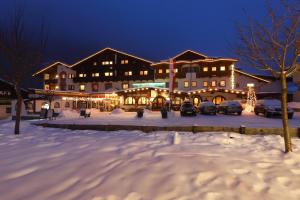 a large building with cars parked in a parking lot at Bergsporthotel Antonie in Gries im Sellrain