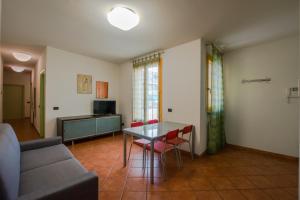 sala de estar con mesa, sillas y sofá en Residence Corso Monferrato, en Alessandria