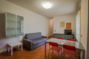 a living room with a couch and a table and chairs at Residence Corso Monferrato in Alessandria