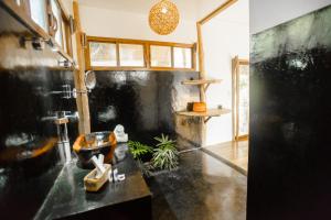 a bathroom with a black counter and a sink at Maligaya Beach Bungalows in El Nido