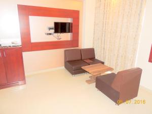 une salle d'attente avec une chaise et une table dans l'établissement Hotel Darshan, à Visnagar