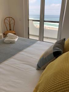 een slaapkamer met een bed en uitzicht op de oceaan bij Salty House - Casa Salgada in Foz do Arelho