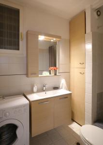 a bathroom with a sink and a washing machine at Alexandros Apartment in Athens