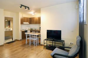 a living room with a couch and a tv and a kitchen at Alexandros Apartment in Athens