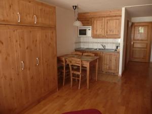 a kitchen with wooden cabinets and a wooden table at Residence Panorama in Villars-sur-Ollon
