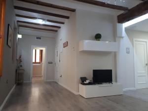 バレンシアにあるAmplio apartamento en centro históricoの白い壁のリビングルーム(薄型テレビ付)