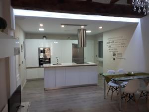 バレンシアにあるAmplio apartamento en centro históricoの白いキャビネット、テーブルと椅子付きのキッチンが備わります。