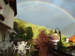 einen Regenbogen über einer Terrasse mit Tischen und Stühlen in der Unterkunft Villa Luise in St. Ulrich in Gröden