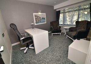 a office with a desk and a chair and a desk and chairs at Güvenay Business Hotel in Ankara