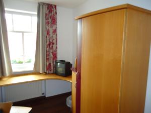 a room with a wooden cabinet and a window at Garni Hotel Kaiserdom in Bamberg