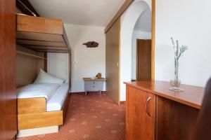 niewielka sypialnia z łóżkiem piętrowym i biurkiem w obiekcie Ferienhotel Bergland w mieście Arzl im Pitztal