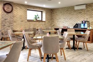 a restaurant with tables and chairs and a clock on the wall at Penzión Pri Mlyne in Nitra