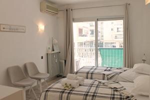 カンヌにあるViva Riviera Rue Victor Cousinのベッドルーム1室(ベッド2台付)、窓、バルコニーが備わります。