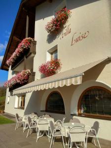 un restaurante con mesas y sillas frente a un edificio en Villa Luise en Ortisei