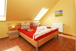 a bedroom with a bed with red sheets and pillows at Haus Clara Wohnung 08 in Ostseebad Koserow