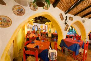 a restaurant with red tables and chairs in a room at Camping Acapulco in Palau