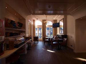 a restaurant with a dining room with a table and chairs at Hotel Clemens in Amsterdam