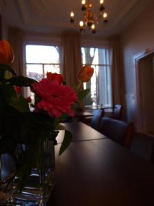 wazon kwiatów siedzący na stole w obiekcie Hotel Clemens w Amsterdamie