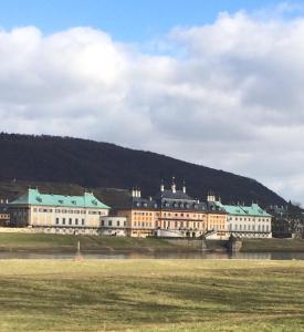 a large building with a hill in the background at Hotel Heidenschanze in Dresden