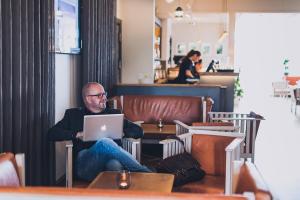 a man sitting in a chair with a laptop at Smögens Hafvsbad in Smögen