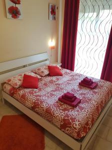 a bedroom with a bed with red pillows and a window at Apartment in Salerno Centro in Salerno