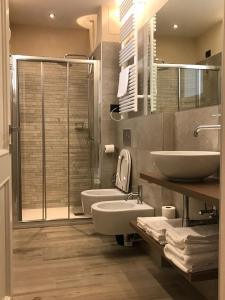 Palazzo Domanto Apartments Parma في بارما: حمام مع مغسلتين ودش
