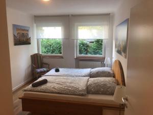 a bedroom with a bed and two windows at Ferienwohnung Messewohnung München Ost in Forstern