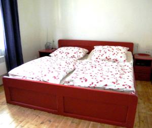 een slaapkamer met een bed met rode bloemen erop bij Rainmühle in Mariánské Lázně