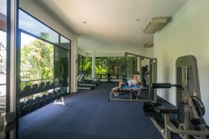 a gym with two people sitting on a bench in the gym at The Palm at Veloche Group by Lofty in Karon Beach