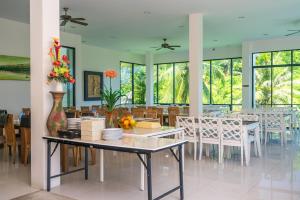 a dining room with a table and chairs and windows at The Palm at Veloche Group by Lofty in Karon Beach