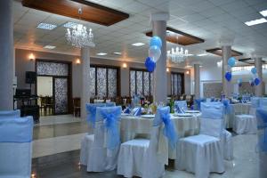 a banquet hall with white tables and blue bows at Hotel Magnolia in Aiud