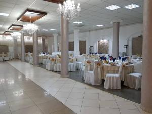 a large banquet hall with white tables and chairs at Hotel Magnolia in Aiud +3 photos