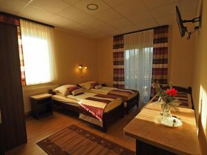 a hotel room with two beds and a table at DW Poronianka in Poronin