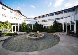 a courtyard with a fountain in front of a building at Hotel Atrium in Târgu Secuiesc
