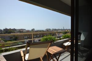 a balcony with two chairs and a view of the city at sunset@leçadapalmeira in Matosinhos