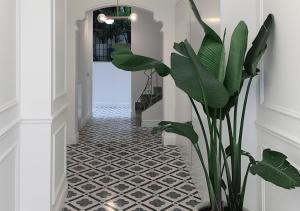 a hallway with a black and white tile floor and a plant at Casa Timoteo Apartamentos Boutique Adults Only in Alcoy