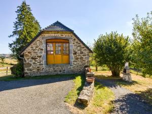 a small stone house with a yellow door at Former farmhouse fully renovated with garden near the Auvergne volcanoes in Calvinet