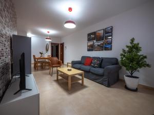 ein Wohnzimmer mit einem Sofa, einem TV und einem Tisch in der Unterkunft Apartamento nuevo con WiFi in Frontera
