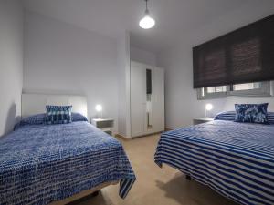 1 Schlafzimmer mit 2 Betten mit blauer und weißer Bettwäsche in der Unterkunft Apartamento nuevo con WiFi in Frontera