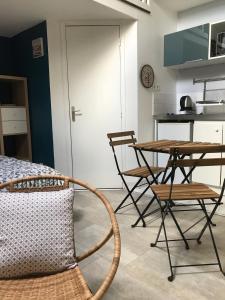 パレゾーにあるPalaiseau - proche Orly et Parisのテーブルと椅子、キッチンが備わる客室です。