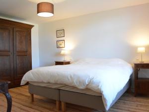 - une chambre avec un grand lit blanc et deux lampes dans l'établissement Heritage Holiday Home in Gedinne With Sauna, à Gedinne
