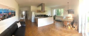a living room with a couch and a table and a kitchen at Ferienwohnung Messewohnung München Ost in Forstern