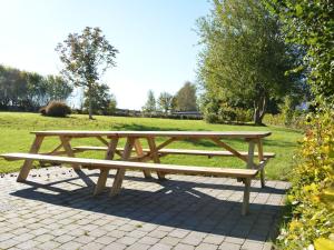 - une table de pique-nique en bois dans un parc avec un champ dans l'établissement Heritage Holiday Home in Gedinne With Sauna, à Gedinne
