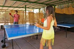 a woman playing a game of ping pong at Club Hotel Residence Baiaverde in Valledoria