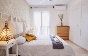 セビリアにあるSanta Cruz Pearl by Valcambreのベッドルーム1室(ベッド1台、ランプ、窓付)